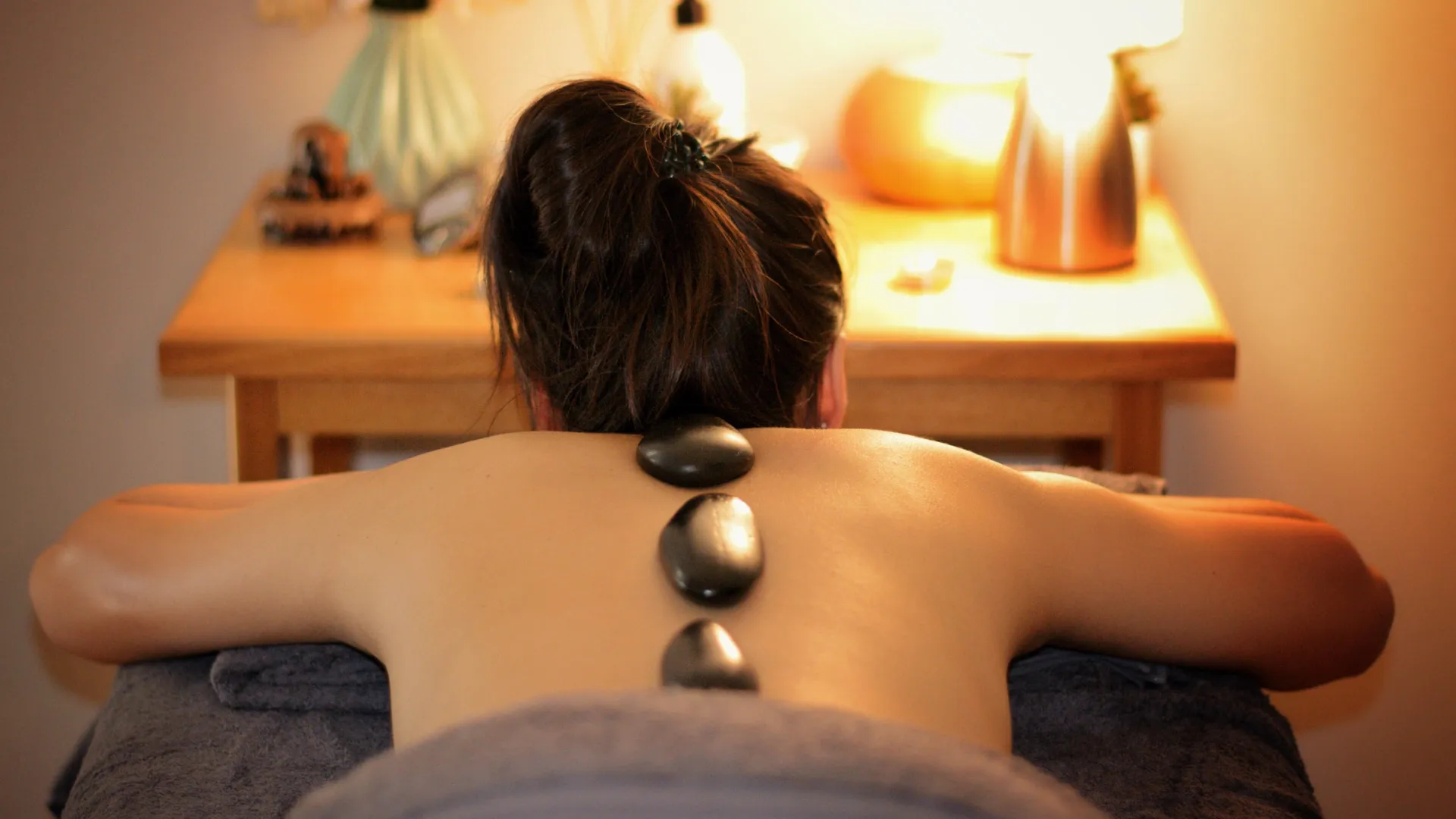 lady having a stone at her back for massage